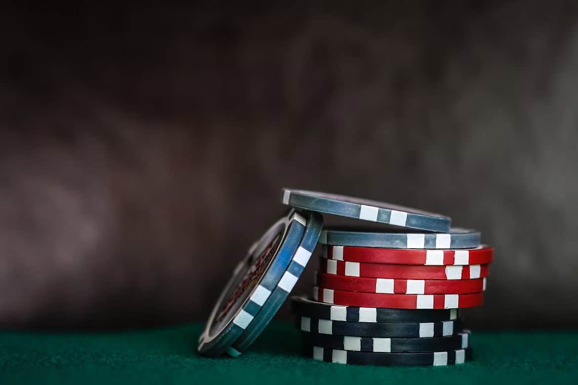 A neat stack of red and blue poker chips on a green felt table symbolizes careful ROI modeling in bot poker solutions