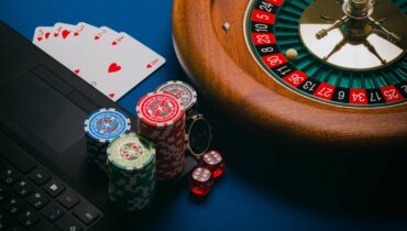 Laptop, roulette wheel, playing cards and colorful chips illustrate the intersection of technology and gambling in bot poker solutions